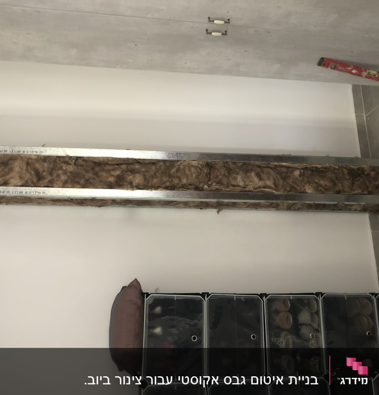 מסגרת מתכת עם חומר בידוד גבעס על קיר